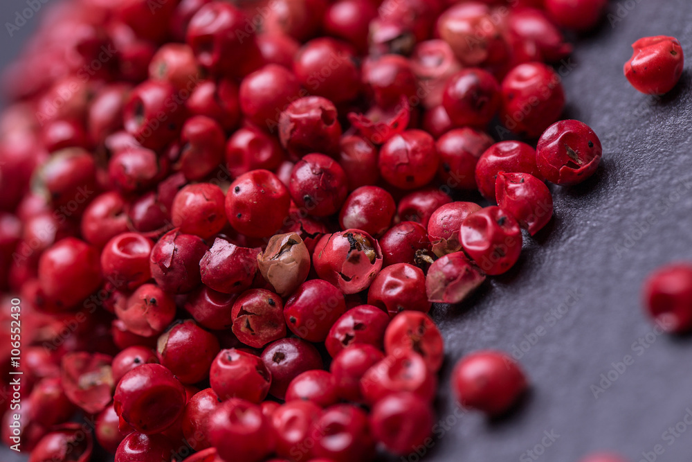 Heaps of pink pepper on a wooden table