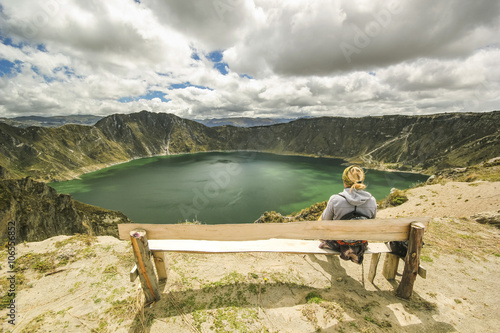 girl sitting on a branch near crater lake photo