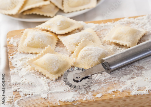 Obraz na plátně Making homemade Italian pasta ravioli with a cutting tool