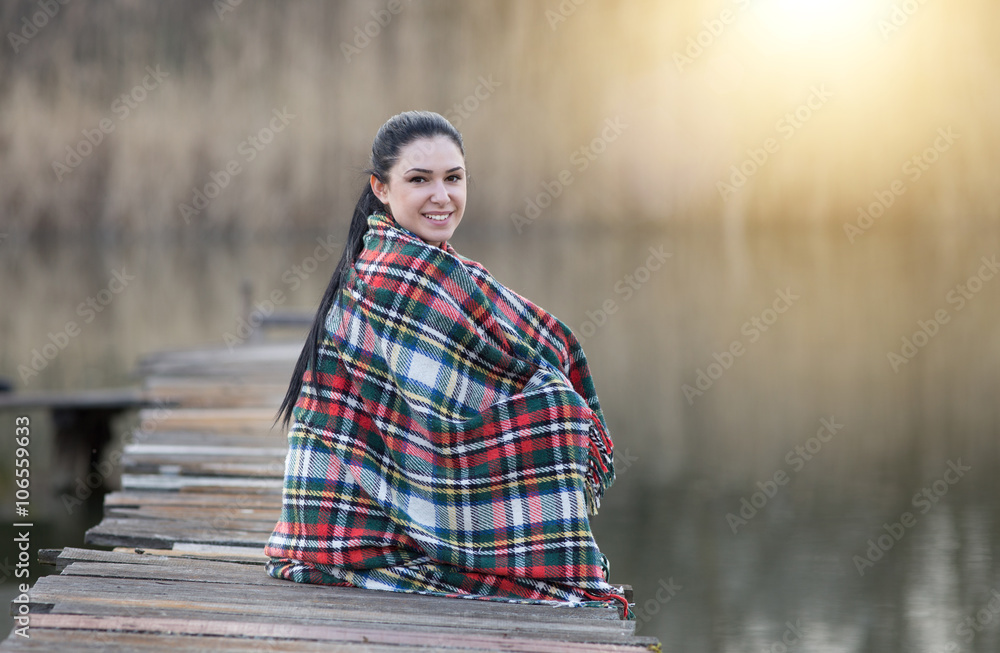 Girl sitting on dock on river