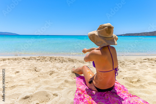 Beautiful young woman lying on the magnificent beach of Elafonis