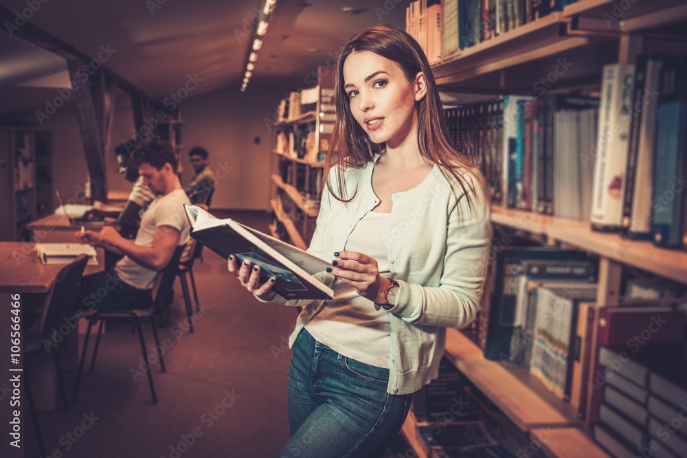 Naklejka premium Multinational group of cheerful students studying in the university library.