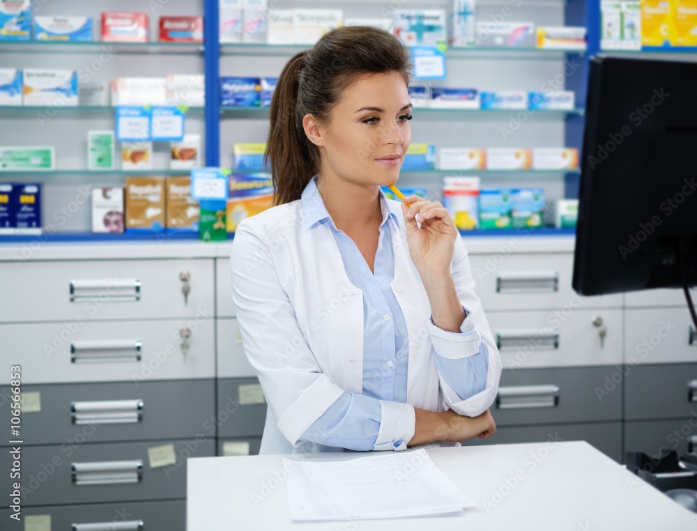 Beautiful smiling young woman pharmacist doing his work in pharmacy. Beautiful smiling young woman pharmacist doing his work in pharmacy.
