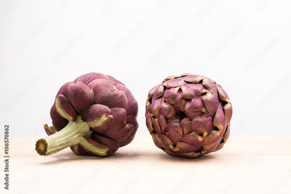 Fototapeta premium Artichokes with wooden kitchen board