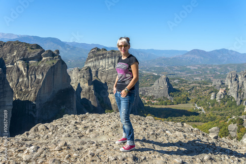 Young beautiful girl standing in front of the magnificent rocks