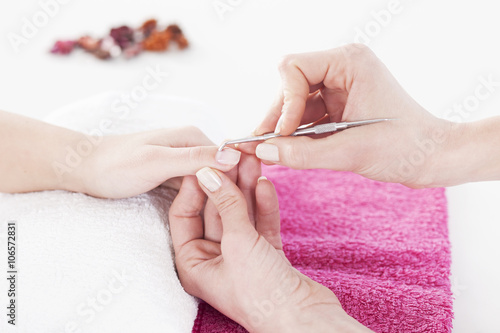 Woman in a nail salon receiving a manicure by a beautician.