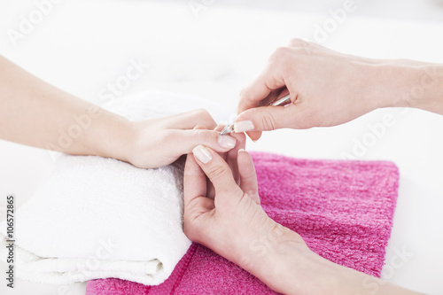 Woman in a nail salon receiving a manicure by a beautician.
