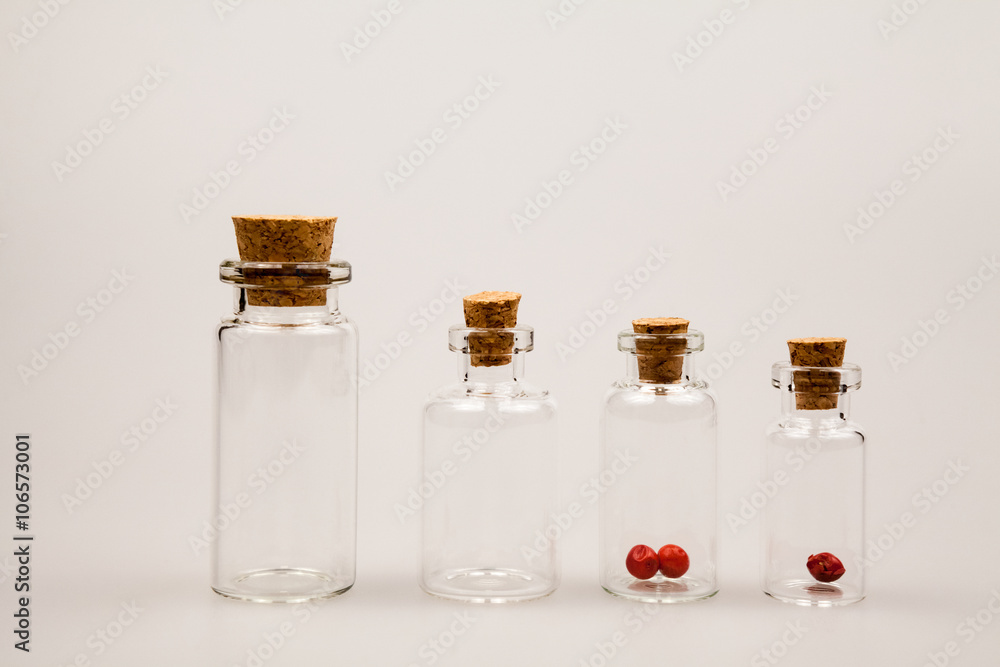Small glass bottles with red pepper and reflexions Small glass bottles with red pepper and reflexions
