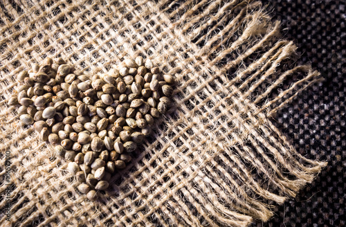 Hemp (cannabis) seeds heart on hemp fabric background