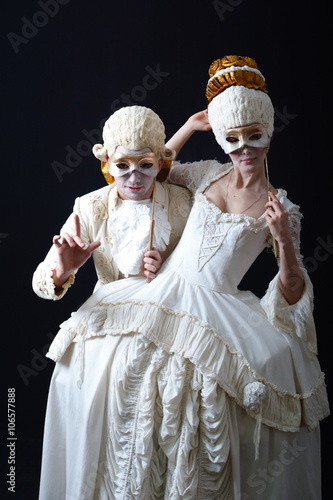 actor and actress in period costume holding a theatrical mask