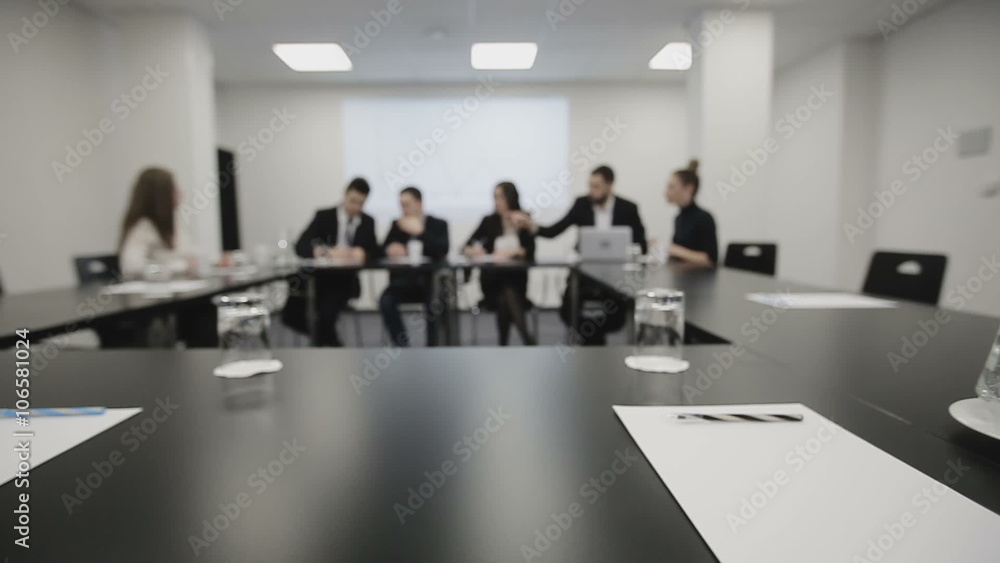 Business team at a meeting: Group of business people discussing, documents and ideas. Defocused footage, slider camera movement. Business team at a meeting: Group of business people discussing, documents and ideas. Defocused footage, slider camera movement.