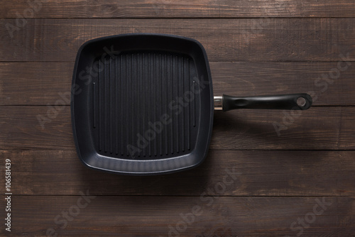 Cast iron griddle pan on wooden background