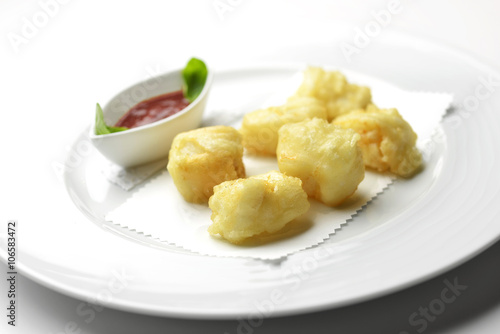 Fried pieces of codfish with tomato sauce