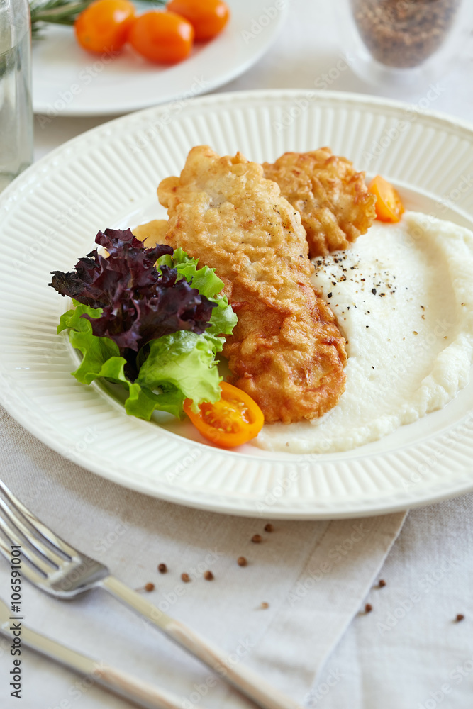 a portion of fried fish with cauliflower puree a portion of fried fish with cauliflower puree