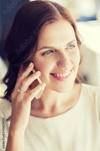 happy woman calling on smart phone at restaurant
