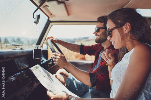 Young couple using a map on a roadtrip for directions