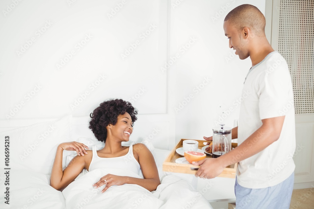 Handsome man bringing breakfast to his girlfriend Handsome man bringing breakfast to his girlfriend