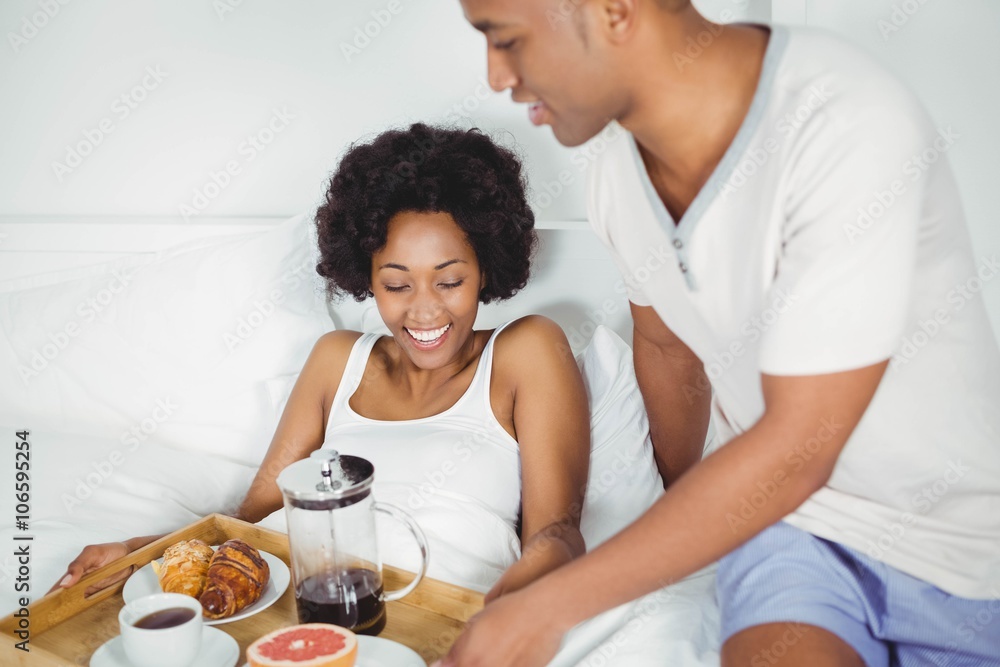 Handsome man bringing breakfast to his girlfriend Handsome man bringing breakfast to his girlfriend