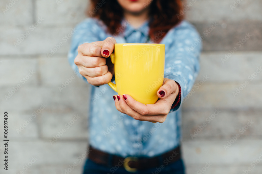 Woman holding yellow cup