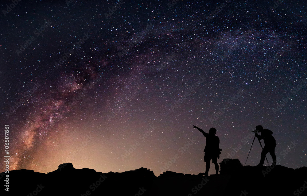Star-catcher. A person is standing next to the Milky Way galaxy