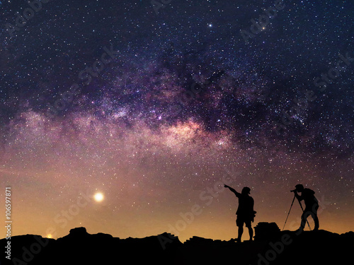Star-catcher. A person is standing next to the Milky Way galaxy