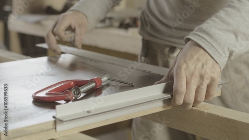 Carpenter measure wooden board by metal straightedge. Goniometry. Treatment. Manufacturer. Close up photo