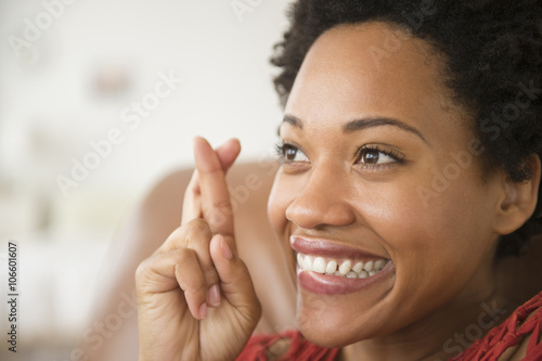 Close up of Black woman smiling with fingers crossed