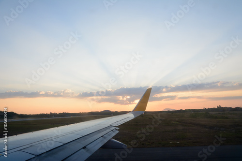 Aircraft wing against with beautiful sky with sun rays