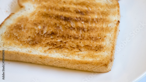 The close up of tasty bread toast on white plate.