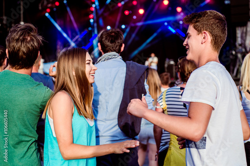 Teenagers at summer music festival having fun, dancing