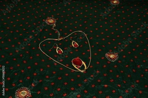 Jewelry display looks like a cartoon face on a green embroidered saree background