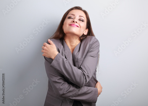 Cuadro en lienzo Happy business woman hugging herself with natural emotional enjo