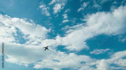 Commercial Passenger Airliner Airplane Flying Across an Idyllic White Cloudy Blue Sky Shortly After Taking Off from Houston TX Hobby Airport on a Day of Perfect Texas Weather photo