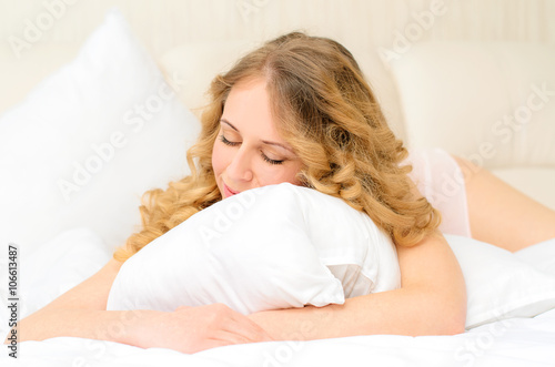 sleeping young woman embracing pillow
