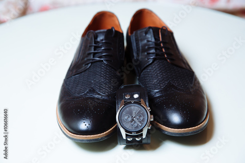 Gentlemans acessory. Shoes and waches on white table photo