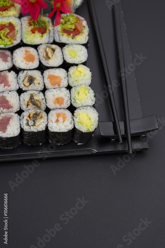 Sushi set on a black plate over dark background