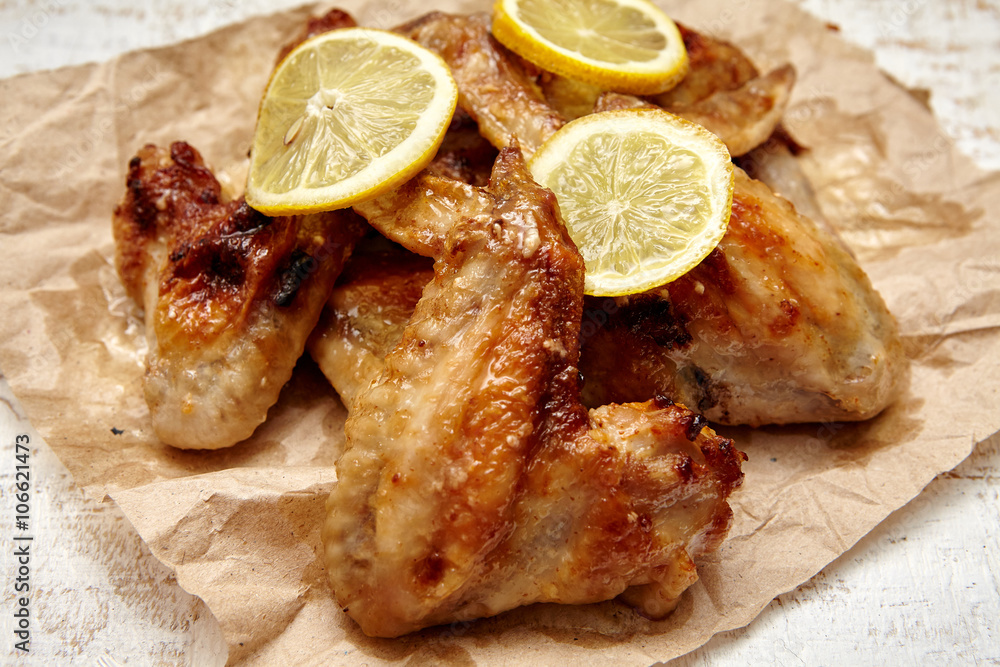 fried chicken wings with lemon on old wooden background fried chicken wings with lemon on old wooden background