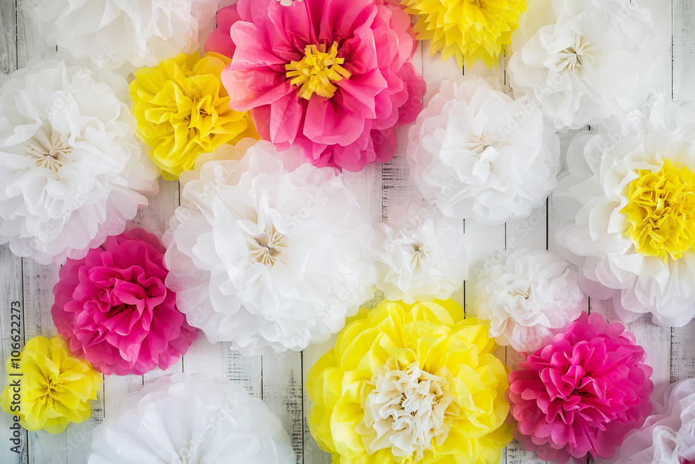 Obraz premium Paper handmade flowers isolated on white wood background. Beautiful floral background of white, pink and yellow colors.