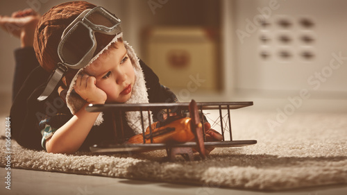 Billede på lærred concept of dreams and travels.  pilot aviator child with a toy a