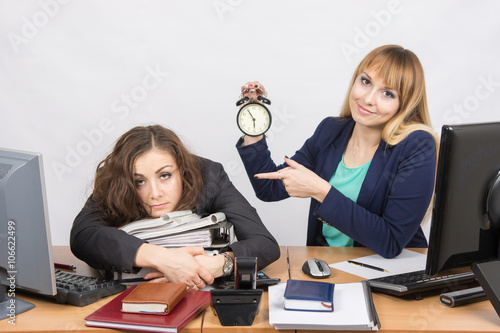 The girl in the office with a smile, indicating the hours and tortured colleague