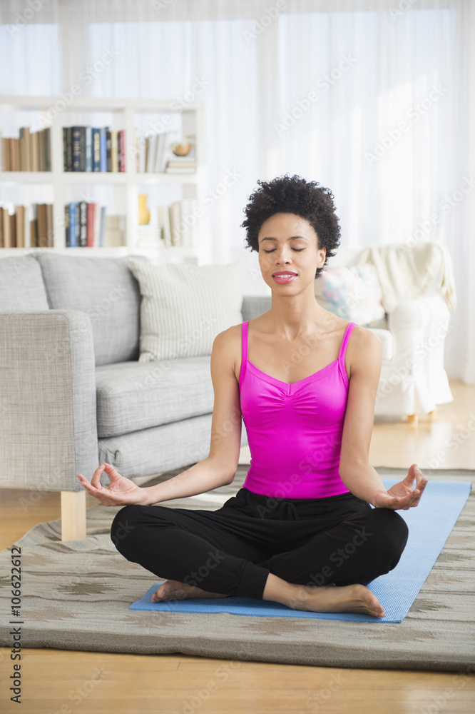 Black woman meditating on yoga mat Black woman meditating on yoga mat