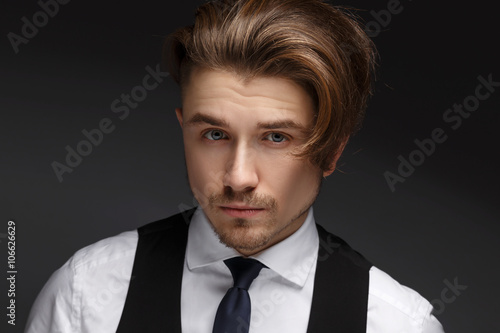 Handsome young gentelman wearing elegant white shirt  and black suit posing on camera. photo