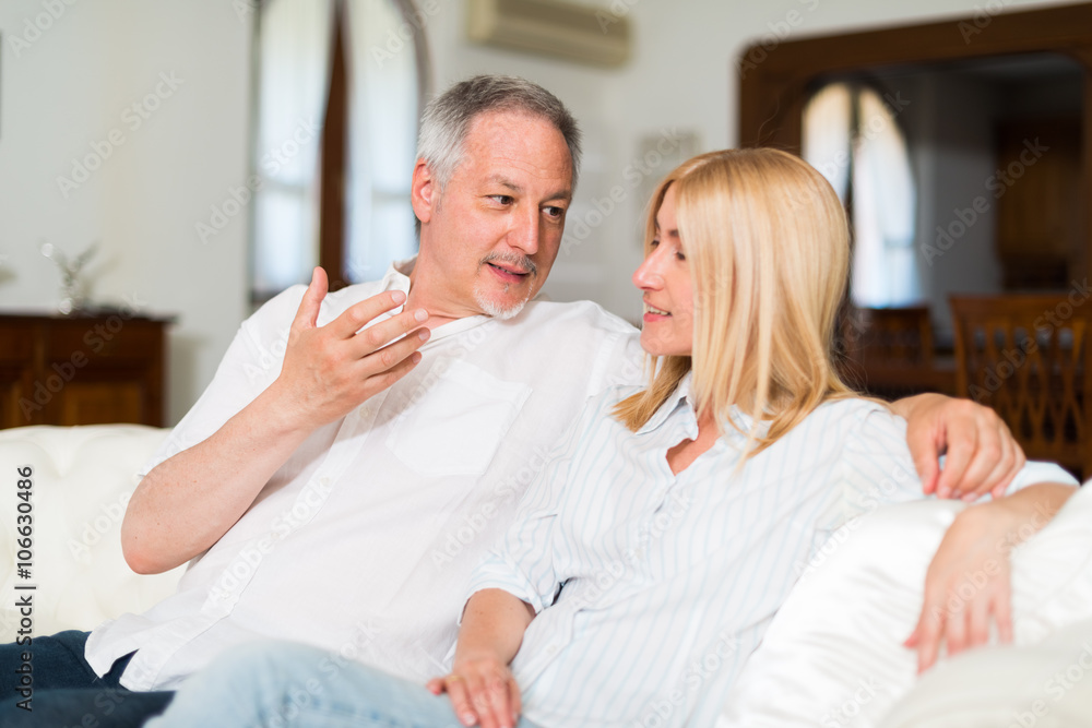 Happy mature couple talking in their home Happy mature couple talking in their home