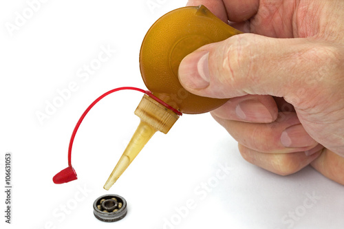 Master lubricates the old bearing of an using a oiler, isolated photo