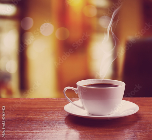 Cup of coffee on table on blured cafe background