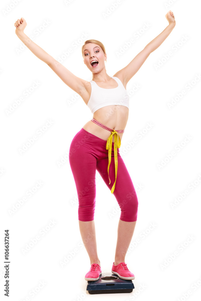 Woman measuring on weighing scale with raised arms Woman measuring on weighing scale with raised arms