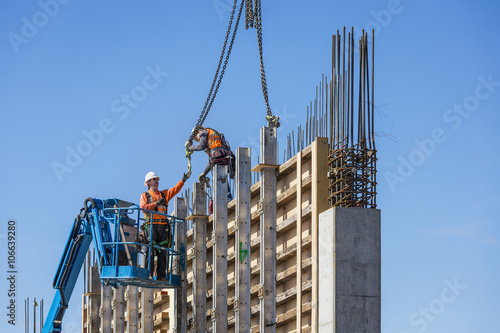 Workers on concrete wall form on construction site
