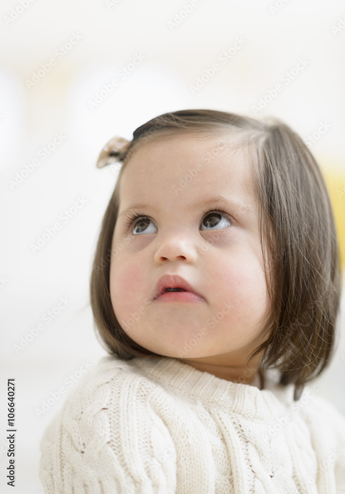 Hispanic toddler with Down syndrome looking up Hispanic toddler with Down syndrome looking up