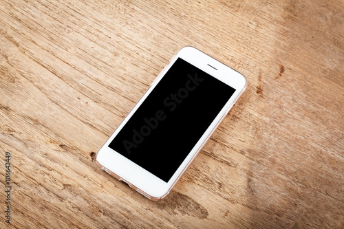 Mobile phone with blank screen mockup isolated on wood table bac