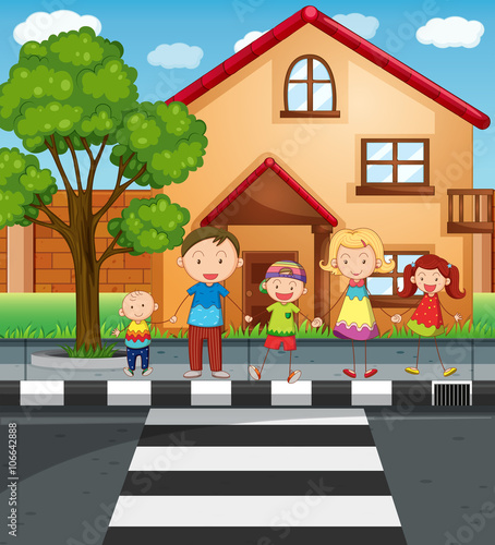 Family holding hands while crossing the road